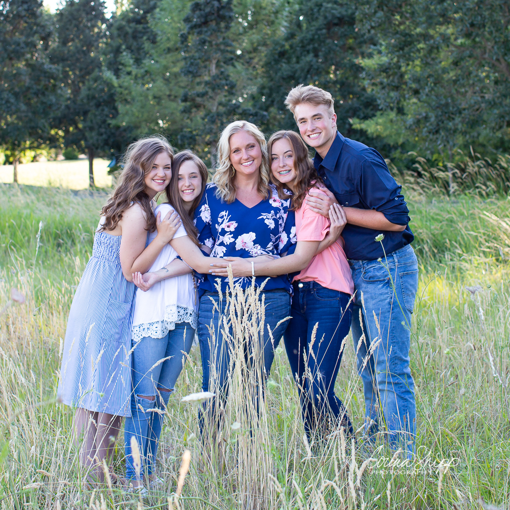 Family posed and hugging in a field